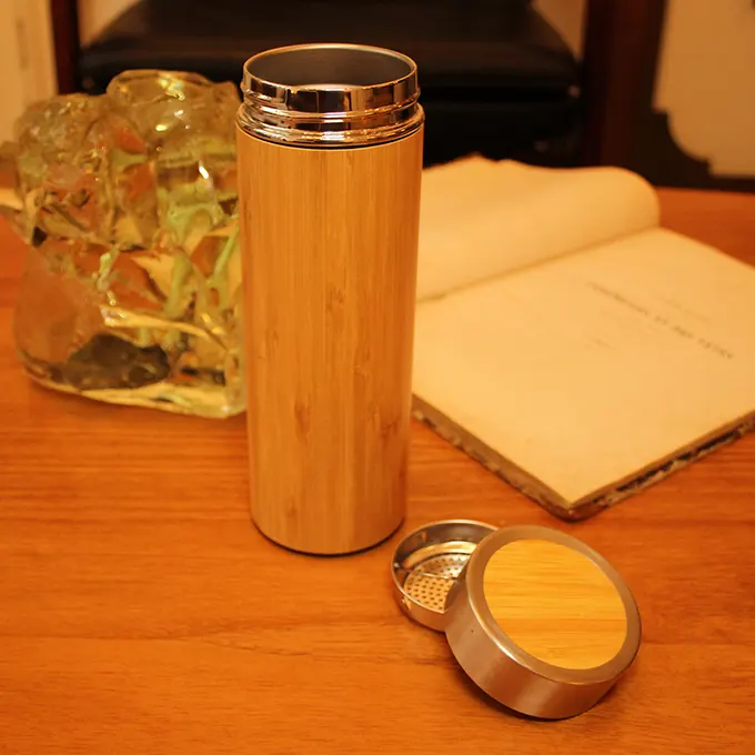 Thermos of tea on a table with a book and decorations
