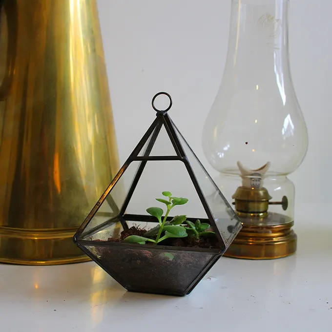 Vase géométrique sur une table avec une lampe à pétrole