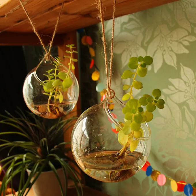 Two vases hanging from a shelf with decorations