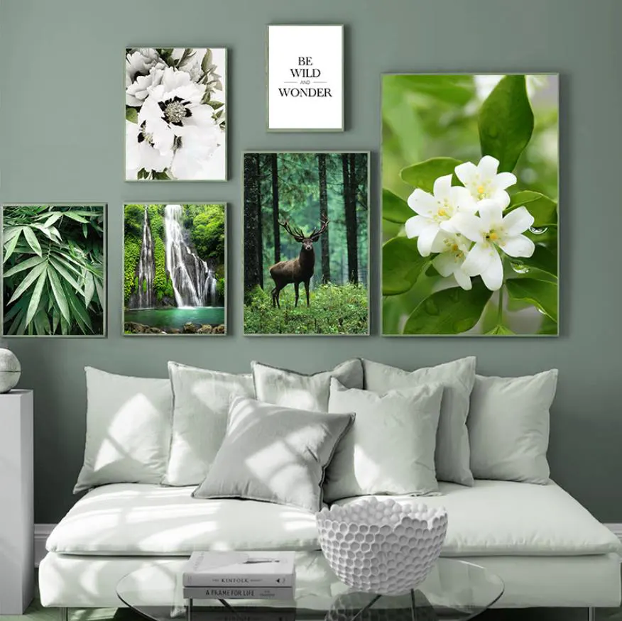 Canvassets met natuurfoto's aan de muur in een woonkamer boven een bank