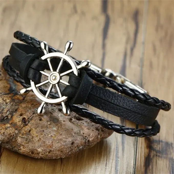 Bracelet noir avec gouvernail, décoratif pour le poignet exposé sur une pierre